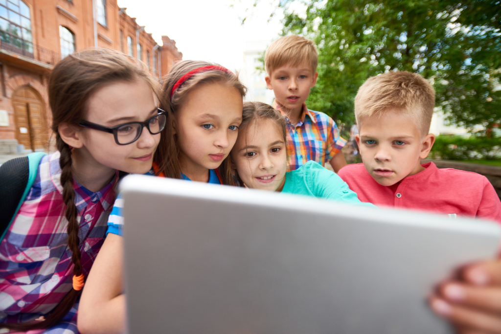 a group of children looking at an ipad app