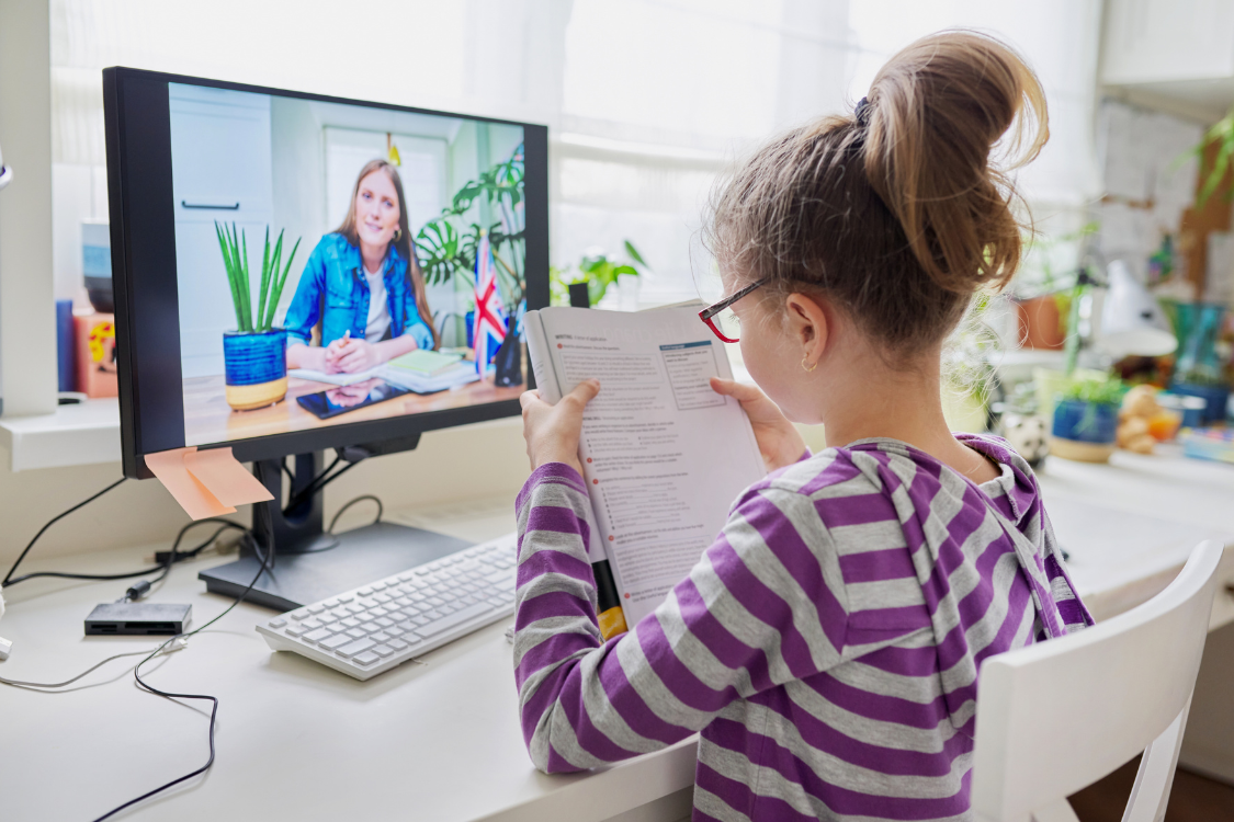 young girl on a video call with an English teacher for remote learning